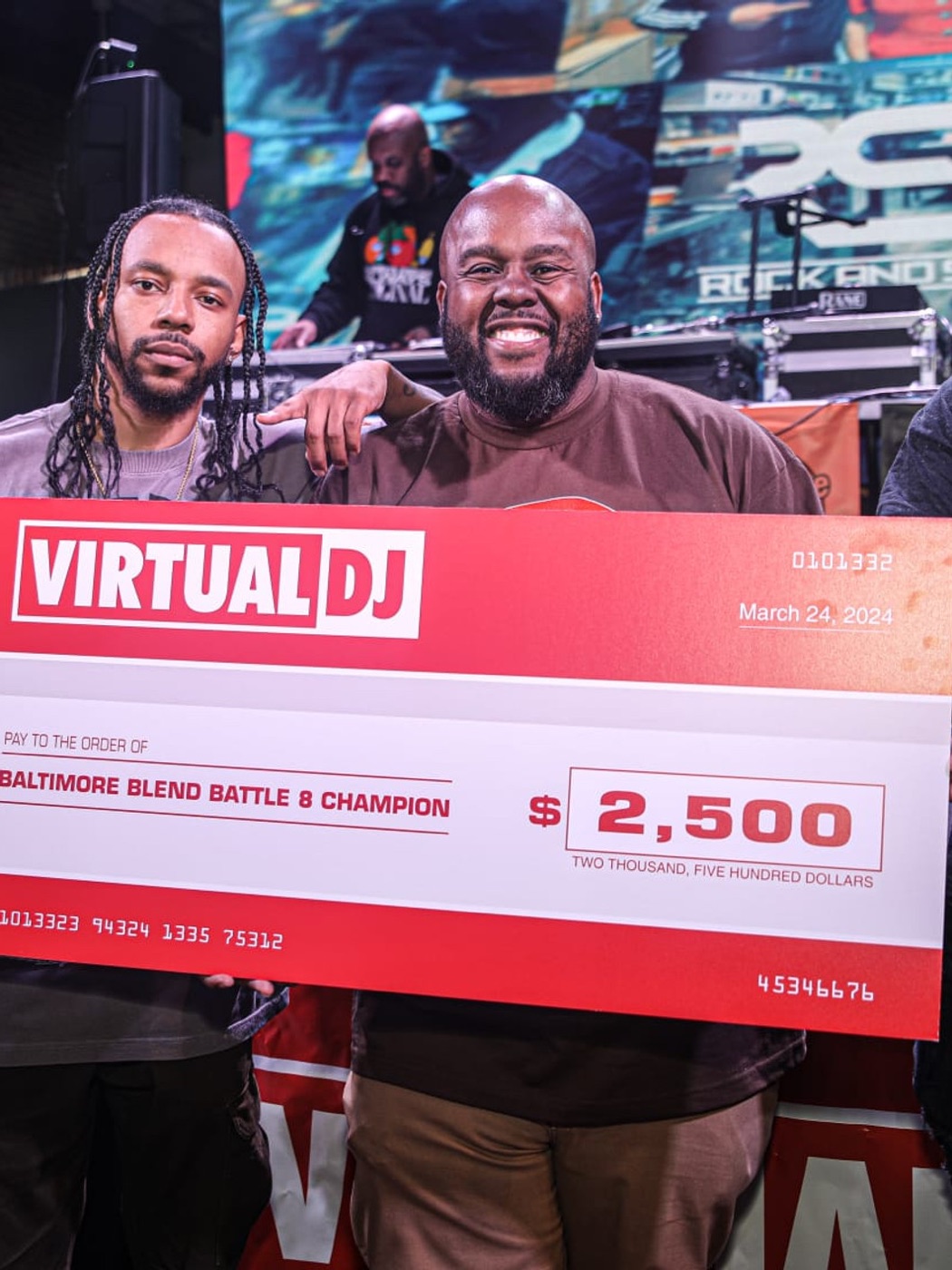 Baltimore Blend Battle champion holding the oversized winner's cheque alongside host Tim Nice
